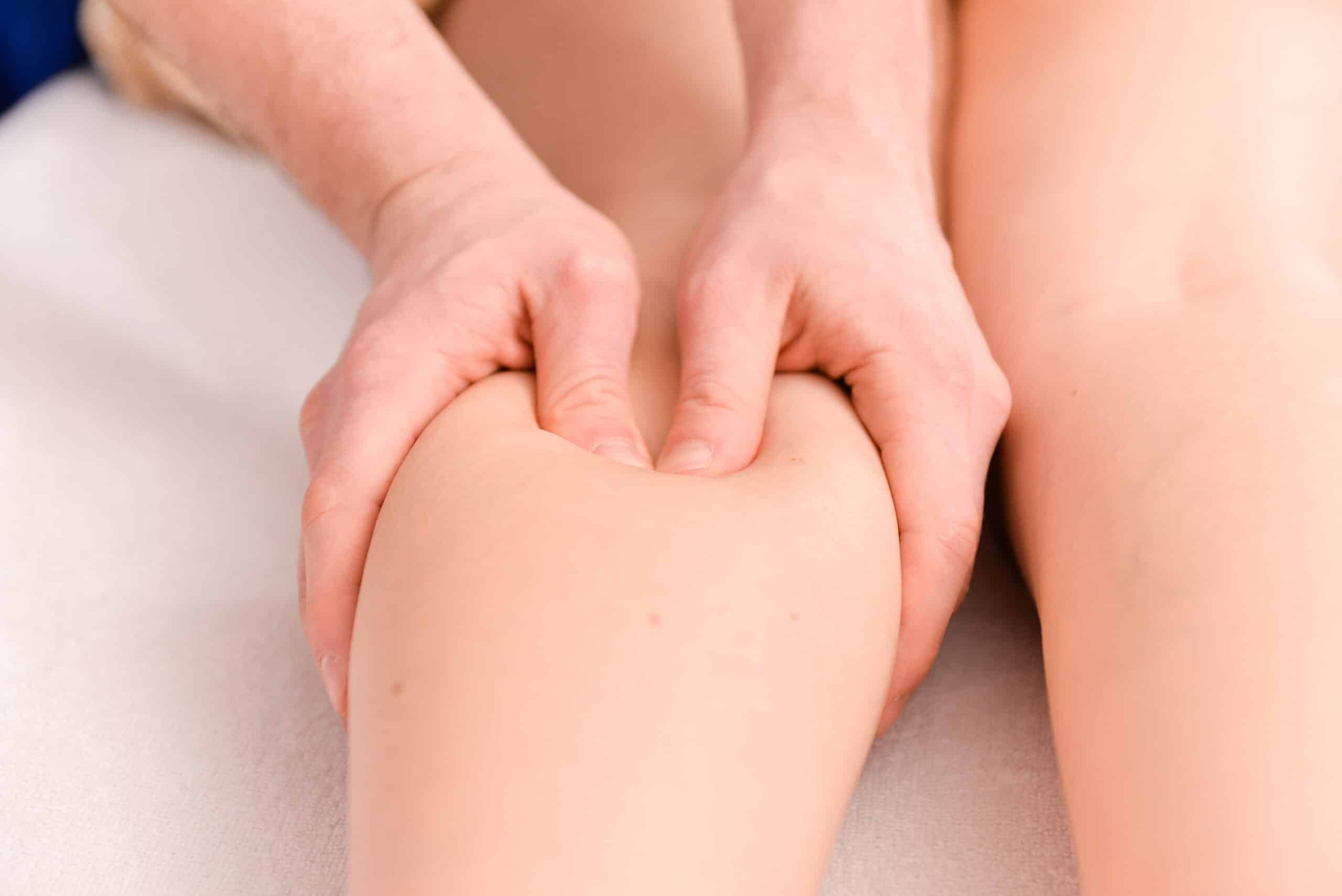 Therapist performing deep tissue leg massage